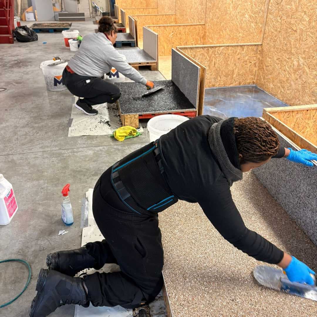 Stagiaires appliquant de la moquette de pierre dans l’atelier de Charny